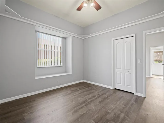a view of an empty room with window and wooden floor