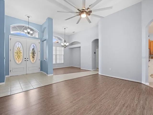 an empty room with fan and windows