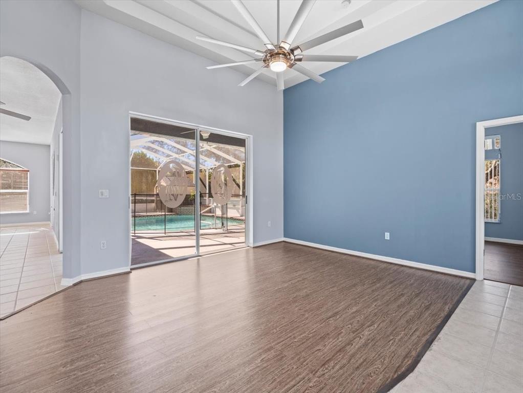 10307 Ridge Top Loop Weeki Wachee, FL 34613 - Photo 9 of 50 an empty room with wooden floor and windows