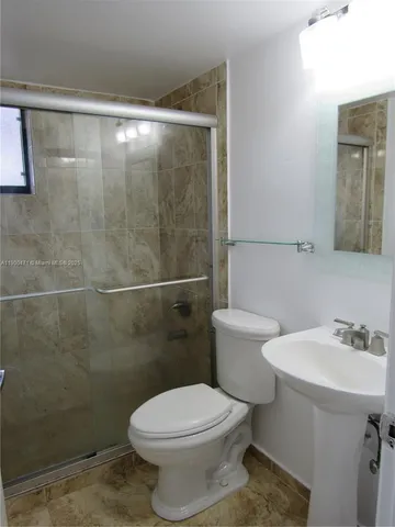 a white toilet sitting next to a bathroom sink