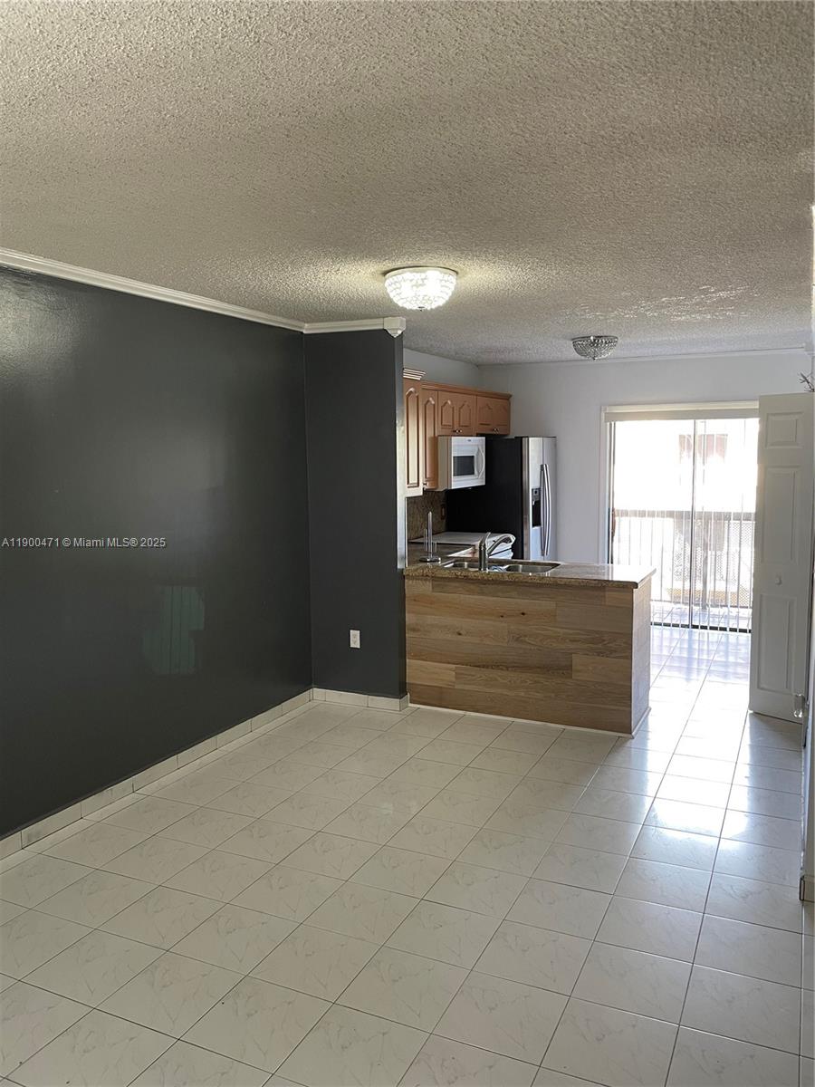 5490 West 21st Court, Unit 308 Hialeah, FL 33016 - Photo 4 of 21 a view of kitchen with refrigerator and window