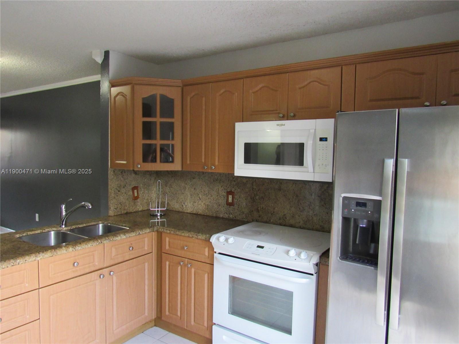5490 West 21st Court, Unit 308 Hialeah, FL 33016 - Photo 6 of 21 a kitchen with a sink and a refrigerator