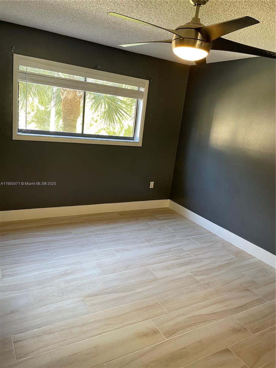 5490 West 21st Court, Unit 308 Hialeah, FL 33016 - Photo 10 of 21 an empty room with wooden floor and windows