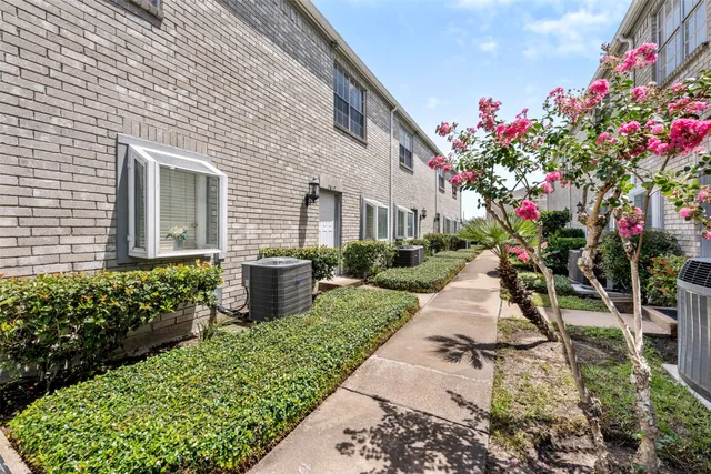 a front view of a house with a yard and potted plants