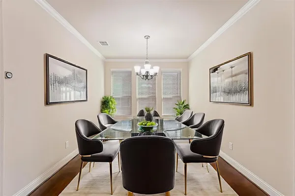 a dining room with furniture a chandelier and wooden floor