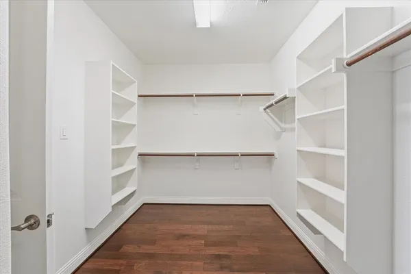 a view of walk in closet with empty racks