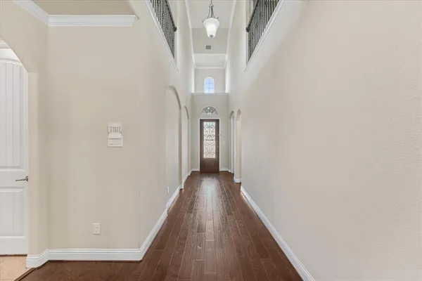 a view of a hallway with wooden floor and staircase