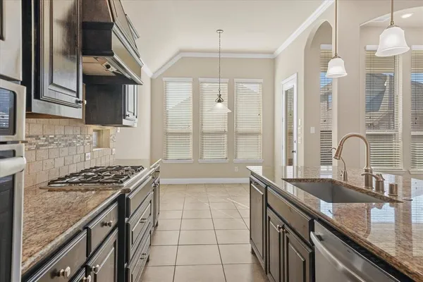a kitchen with granite countertop a sink stove and cabinets