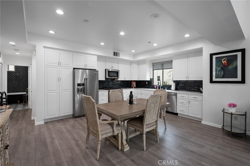 5441 Ocean, Unit 101 Hawthorne, CA 90250 - Photo 7 of 37 a kitchen with stainless steel appliances kitchen island granite countertop a refrigerator a stove a sink a dining table and chairs with wooden floor