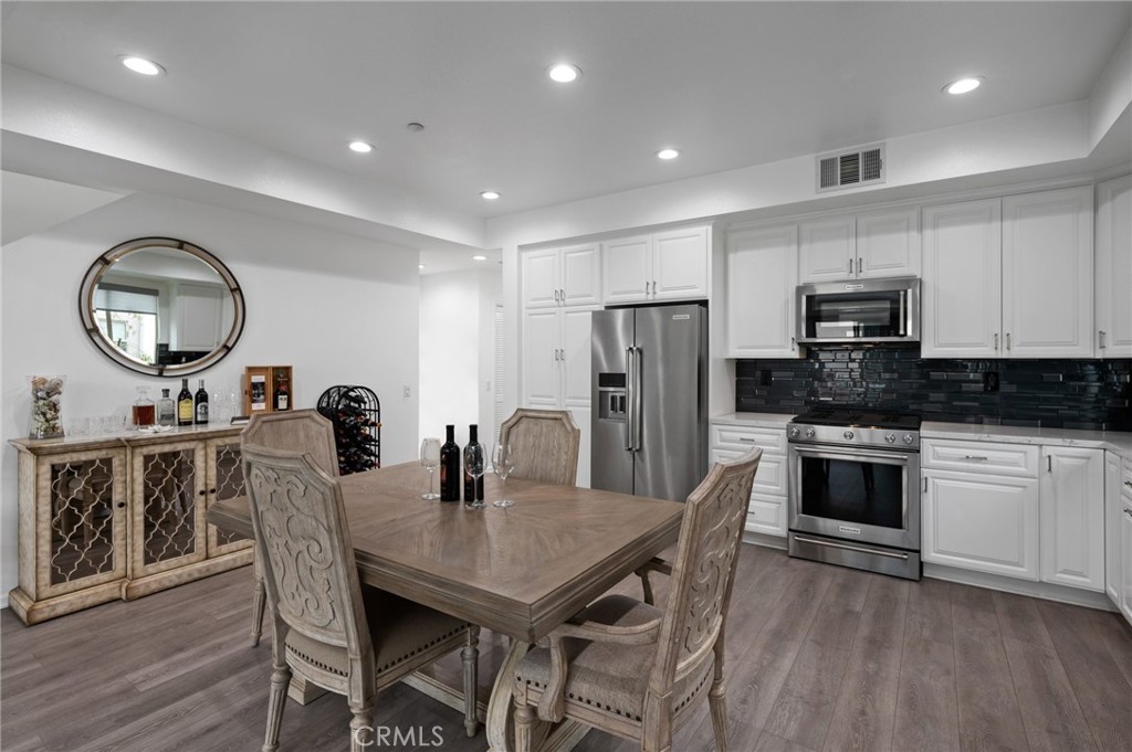 5441 Ocean, Unit 101 Hawthorne, CA 90250 - Photo 9 of 37 a kitchen with stainless steel appliances kitchen island granite countertop a dining table chairs and refrigerator