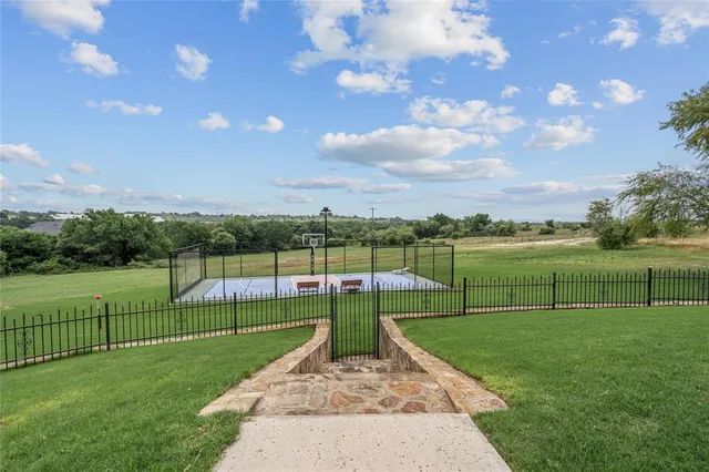 a view of a tennis ground with large trees