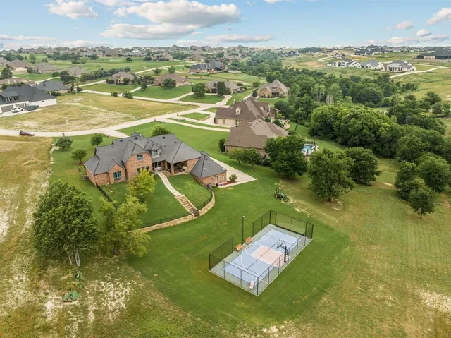 a view of a white house with a big yard and potted plants