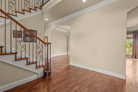 an empty room with windows a fireplace and wooden floor