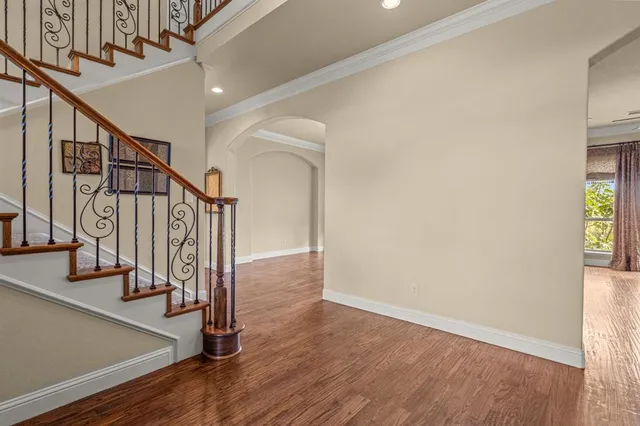 an empty room with windows a fireplace and wooden floor