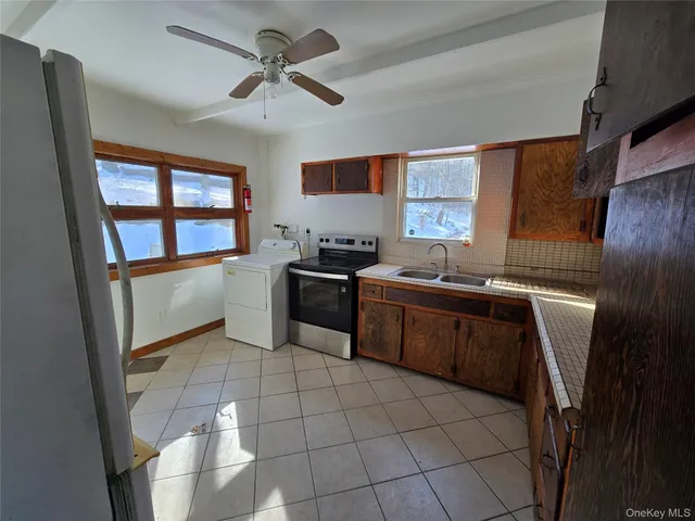 a kitchen with a sink a stove cabinets and a window