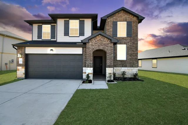 a front view of a house with a garden and garage