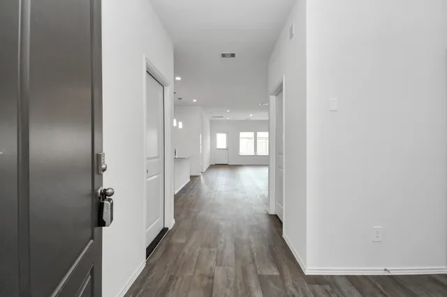 a view of a hallway with wooden floor