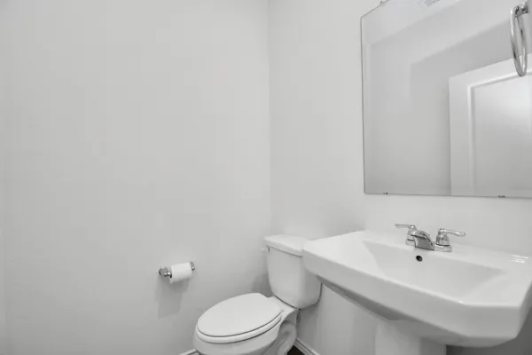a bathroom with a sink a toilet and mirror