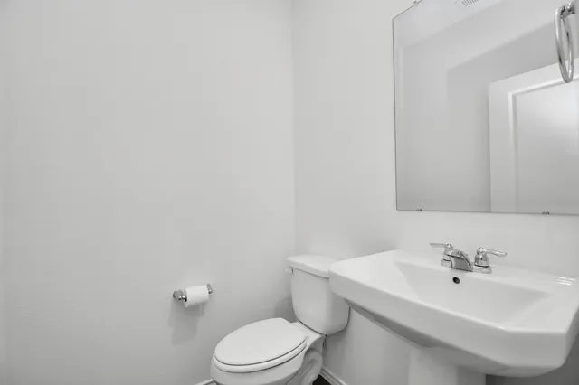 a bathroom with a sink a toilet and mirror