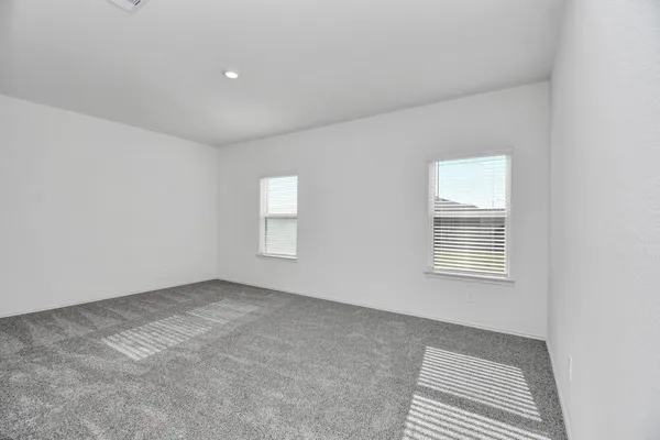 a view of an empty room with closet and entryway