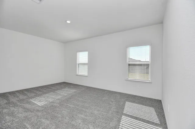 a view of an empty room with closet and entryway