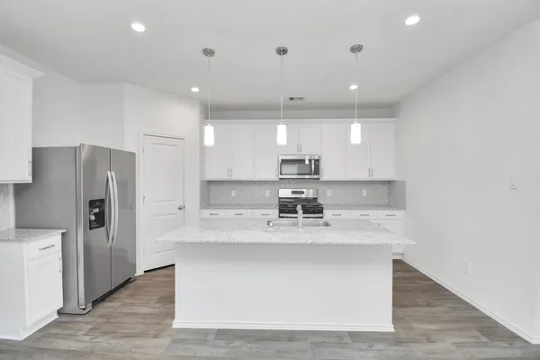 a kitchen with stainless steel appliances granite countertop a sink a refrigerator and a stove