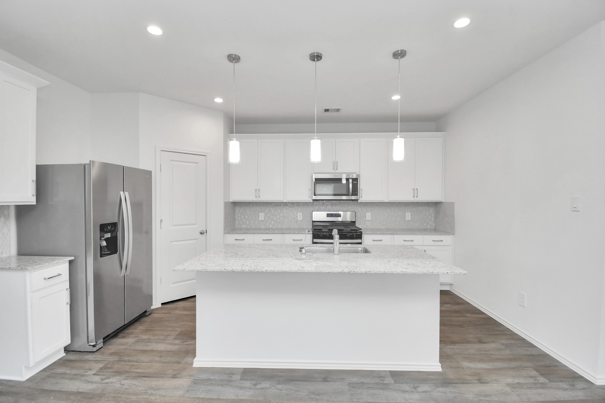 30903 Rockstock Road Fulshear, TX 77441 - Photo 3 of 42 a kitchen with stainless steel appliances granite countertop a sink a refrigerator and a stove