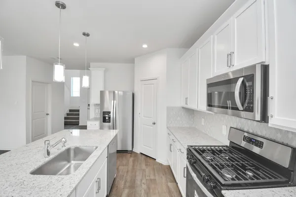 a kitchen with stainless steel appliances granite countertop a stove and a sink