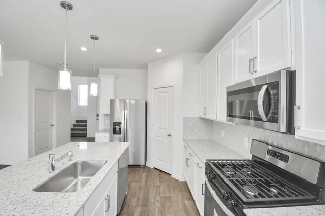 a kitchen with stainless steel appliances granite countertop a stove and a sink