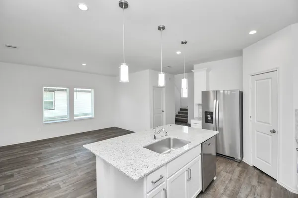 a kitchen with stainless steel appliances granite countertop a sink a refrigerator and a stove