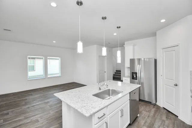 a kitchen with stainless steel appliances granite countertop a sink a refrigerator and a stove