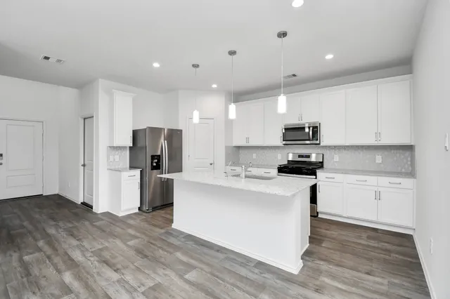 a kitchen with stainless steel appliances a refrigerator stove microwave and cabinets