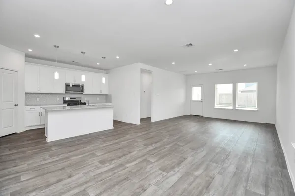 a view of kitchen with kitchen island white cabinets and wooden floor