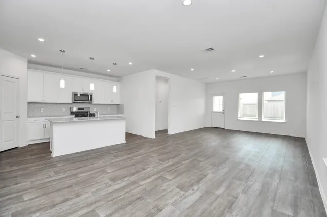 a view of kitchen with kitchen island white cabinets and wooden floor