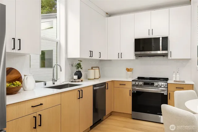 a kitchen with stainless steel appliances a sink a stove and microwave