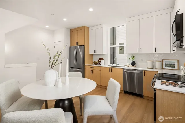 a kitchen with stainless steel appliances a white table and chairs