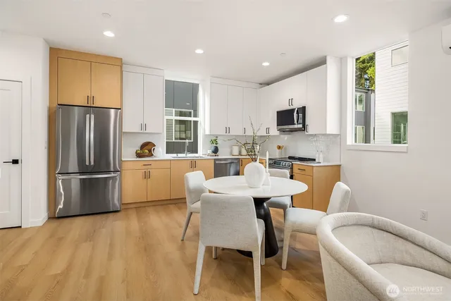 a kitchen with a refrigerator a stove a microwave oven a sink with island and chairs