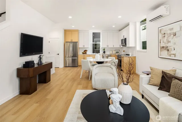 a living room with furniture a flat screen tv and kitchen view