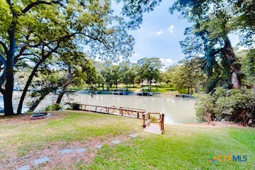 a view of a lake with a bench and trees