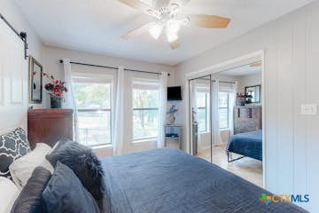 510 Cypress Ridge Road McQueeney, TX 78123 - Photo 12 of 32 a bedroom with a bed and glass door