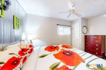 a bedroom with a bed and dresser with mirror