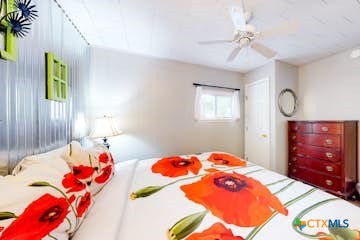 510 Cypress Ridge Road McQueeney, TX 78123 - Photo 17 of 32 a bedroom with a bed and dresser with mirror