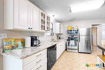 510 Cypress Ridge Road McQueeney, TX 78123 - Photo 21 of 32 a kitchen with stainless steel appliances granite countertop a refrigerator sink and stove