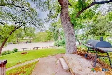 a view of a backyard with table and chairs under an umbrella