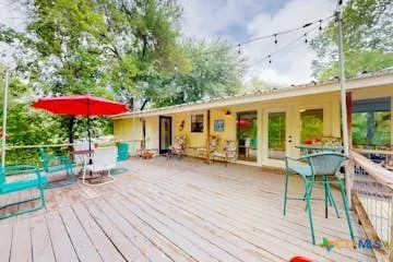 a view of a house with backyard sitting area and wooden floor