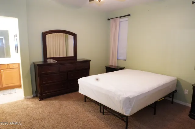 a bed sitting in a bedroom and a mirror