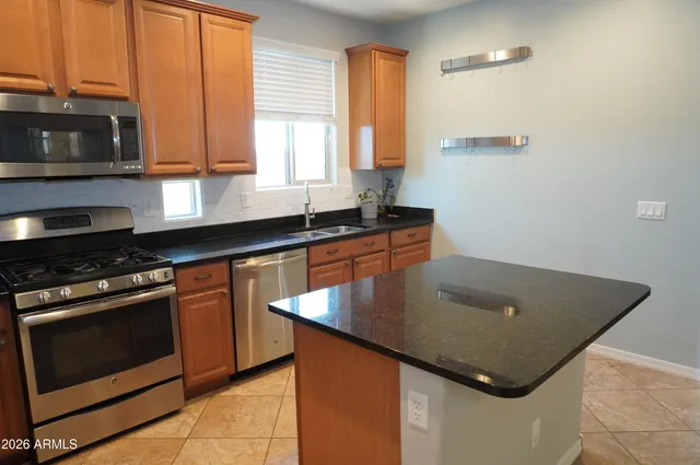 a kitchen with stainless steel appliances granite countertop a sink a stove and a microwave