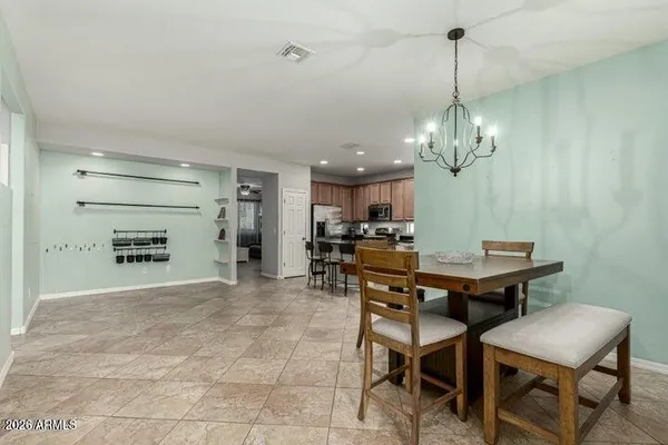 a view of a dining room and livingroom with furniture wooden floor a chandelier