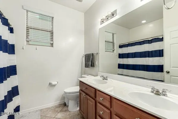 a bathroom with a double vanity sink toilet and a mirror