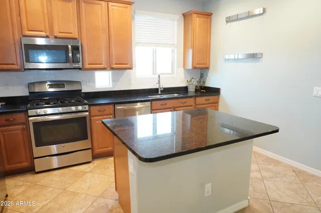 a kitchen with stainless steel appliances granite countertop a sink a stove and a microwave